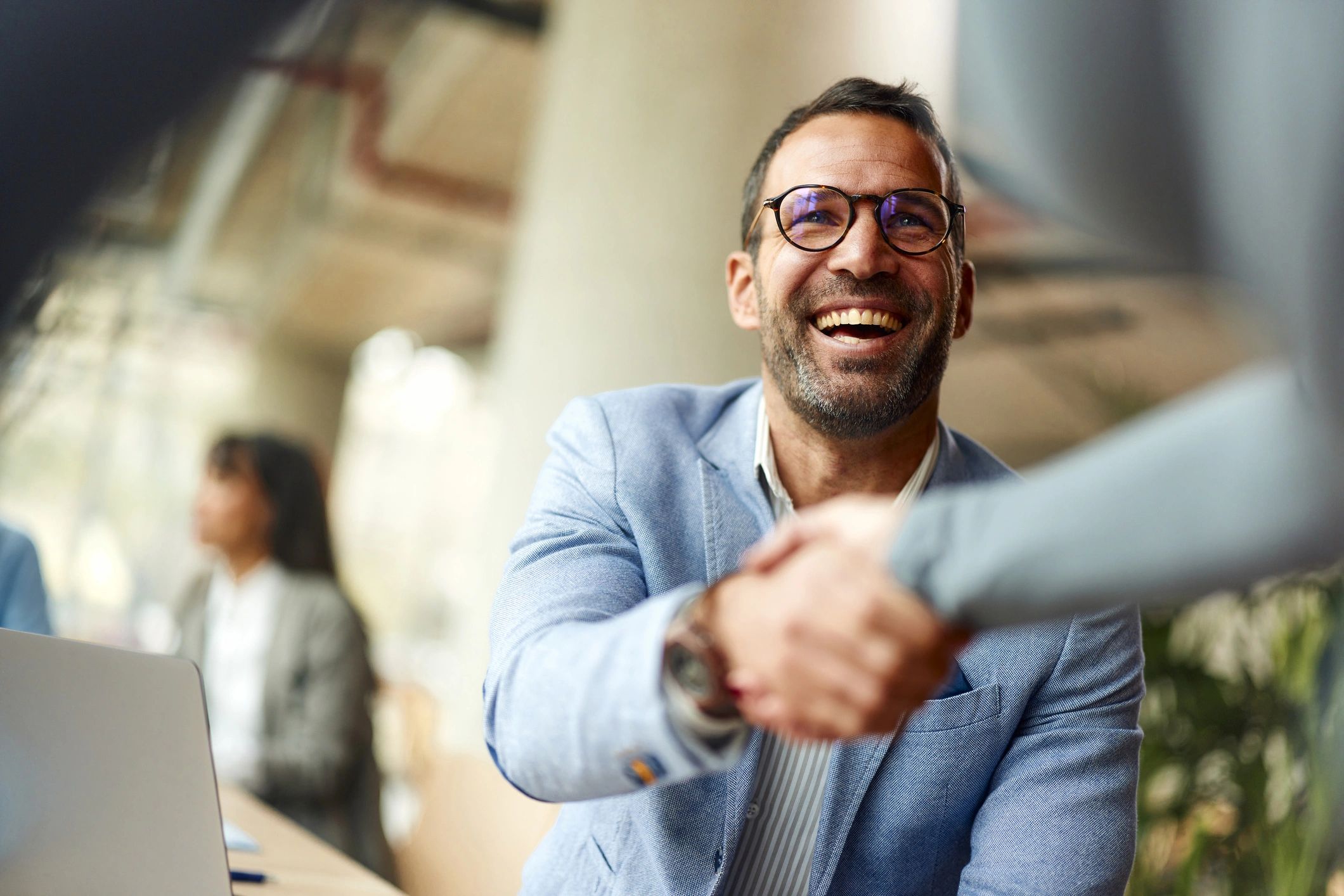 Business professionals shaking hands during a meeting in the office