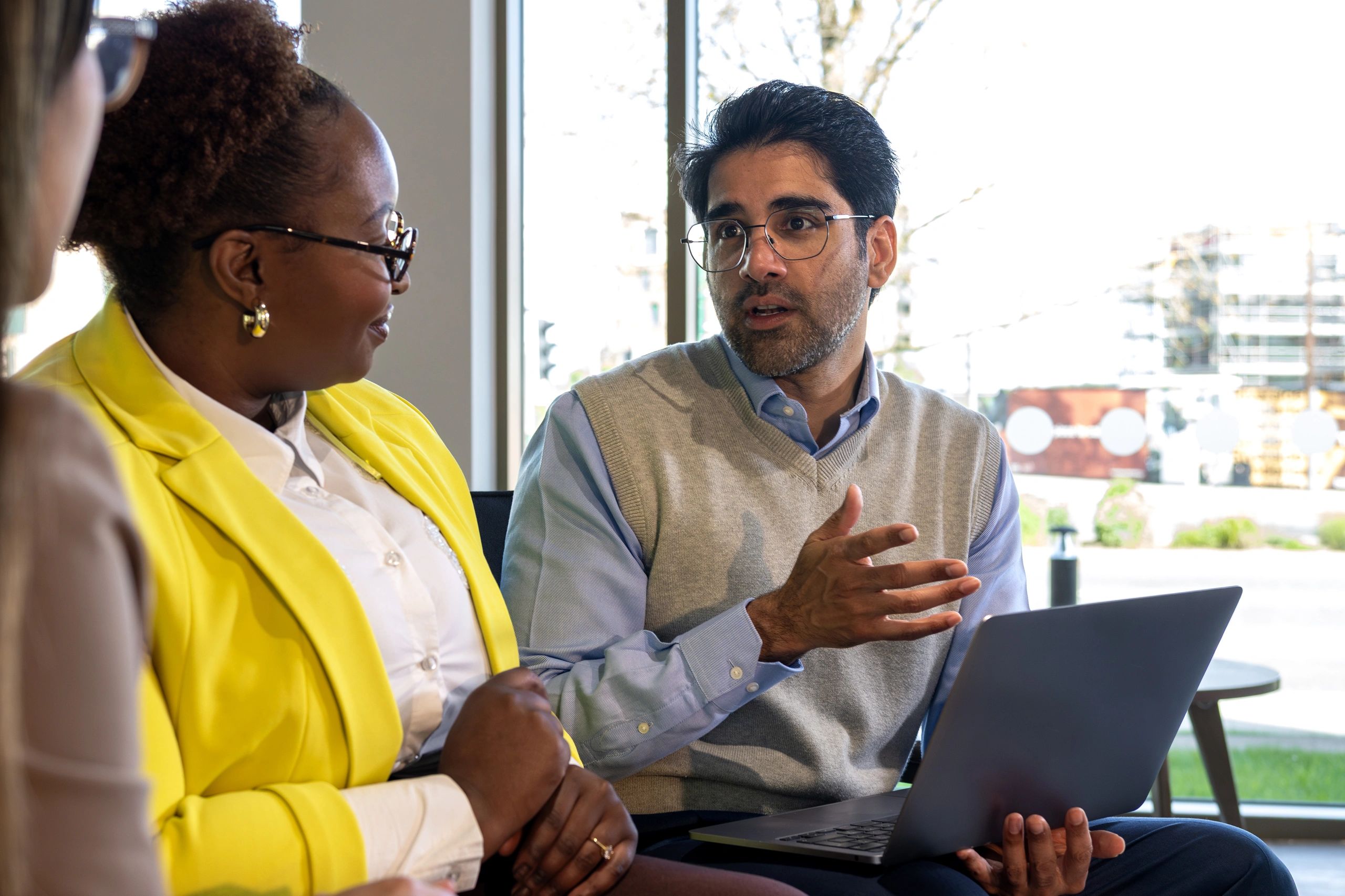 Colleagues reviewing work on a laptop in a modern office